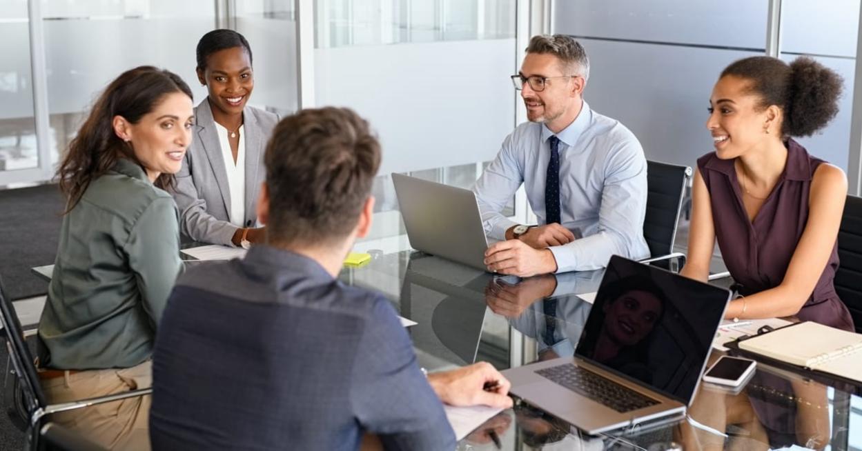Group of business people have a discussion in conference room. Formal business team brainstorming over new project. Mature businessman and businesswoman talking and working  while sitting in modern conference room with business partners.